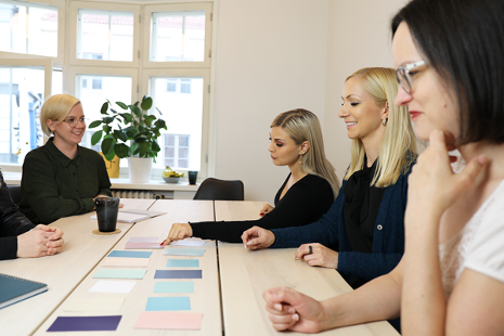 Markkinointitoimisto Kuplin työntekijät kokoontuneena pöydän ääreen Markkinointitoimisto Kuplin työntekijät kokoontuneena pöydän ääreen